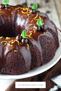 a bundt cake with chocolate frosting and sprinkles on a white plate