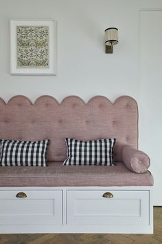 a pink couch with two pillows on it