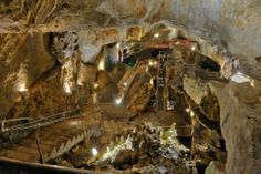 the inside of a cave with stairs leading up to it and lights in the ceiling