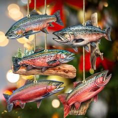 four fish hanging from strings on a christmas tree