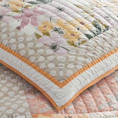 a quilted bedspread with flowers and leaves on it