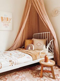 a bed with a canopy over it and pillows on the bottom floor in a bedroom