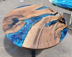 a table made out of wood with blue paint on it's surface and some other items in the background