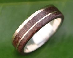 a wooden ring sitting on top of a green leaf