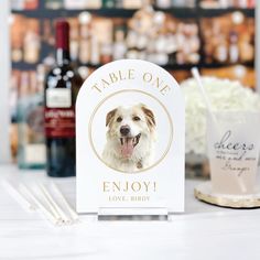 a table sign with a dog's face on it and two straws next to it