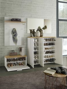 a room filled with lots of white shelves and shoes on top of each shelf in front of a window