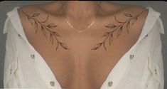 the back of a woman's neck with leaves on it and a chain around her neck