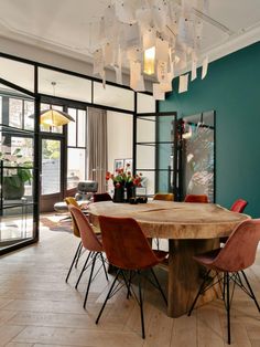 a dining room table with chairs and a chandelier hanging from it's ceiling