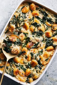 a casserole dish with spinach, potatoes and chicken in it on a table