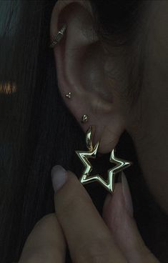 a close up of a person's ear with a star shaped earrings on it