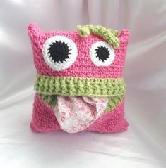 a crocheted pink and green pillow with eyes