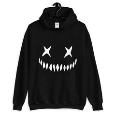 "Get creepy and cozy in this Creepy Pumpkin Face Horror Hoodie. Unisex fit with a large pocket and double lined hood. Everyone needs a cozy go-to hoodie to curl up in, so go for one that's soft, smooth, and stylish. It's the perfect choice for cooler evenings! * 50% cotton, 50% polyester  * Double-lined hood * Double-needle stitching throughout  * Air-jet spun yarn with a soft feel and reduced pilling * 1x1 athletic rib knit cuffs and waistband with spandex * Front pouch pocket  Sizes (inches)   Small - (Width: 20\"- Length: 26\")  Medium - (Width: 22\" - Length: 27\")  Large - (Width: 24\" - Length: 28\")  XL - (Width: 26\" - Length: 29\")  XXL - (Width: 28\" - Length: 30\")  XXXL - (Width: 30\" - Length: 31\")  (unavailable in Green)  XXXXL - (Width: 32\" - Length: 32\") (unavailable in Black Emo Hoodie For Winter, Black Hooded Emo Sweatshirt, Grunge Hoodie With Drawstring For Fall, Emo Cotton Sweatshirt For Winter, Halloween Streetwear Hoodie, Grunge Halloween Sweatshirt With Drawstring Hood, Alternative Halloween Hoodie Sweatshirt, Alternative Style Halloween Hoodie Sweatshirt, Halloween Hoodie With Crew Neck For Streetwear