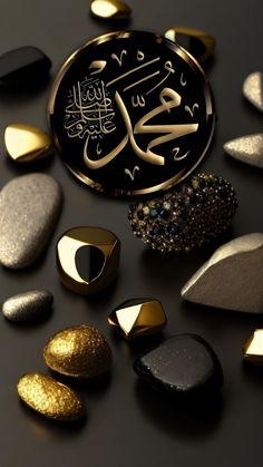 some gold and black stones are laying on a table with an arabic calligraphy in the middle