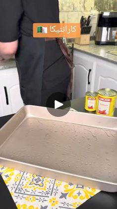 a person standing in a kitchen next to a pan with food on top of it