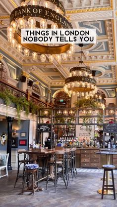 the inside of a restaurant with chandeliers hanging from the ceiling and lights above it