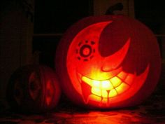 two carved pumpkins sitting on top of a table