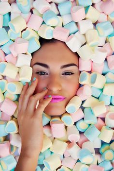 a woman is surrounded by marshmallows