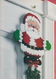 a cross stitch santa clause hanging on the front door