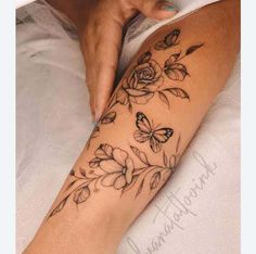 a woman's arm with flowers and butterflies tattoo on the left side of her leg