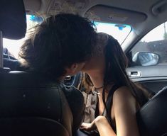 a man and woman kissing in the back seat of a car