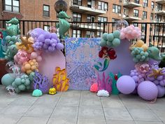 an assortment of balloons and decorations for a little mermaid birthday party