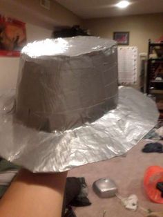 a silver hat sitting on top of a table covered in tin foil