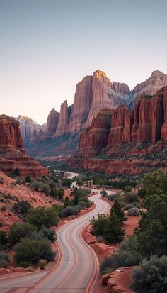 a winding road in the desert with red rocks and trees on both sides at sunset