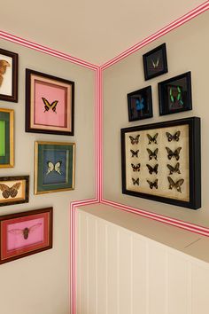 there are many framed pictures on the wall with different colors and shapes in this room