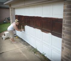 a woman is painting the side of a garage door with brown paint and white trim