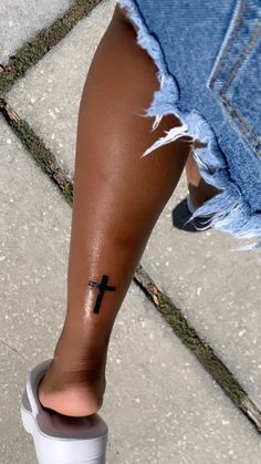 a person with a cross tattoo on their leg