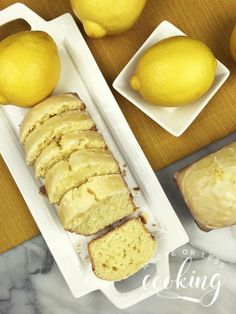 slices of lemon bread sitting on top of a white plate next to sliced lemons