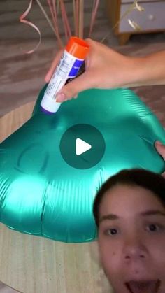 a woman is holding an inflatable green object