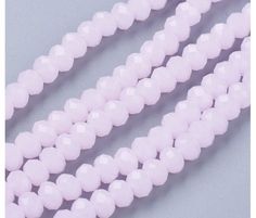 three strands of white beads on a gray background