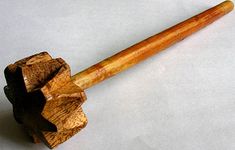 an old wooden pipe resting on top of a piece of wood with a black handle