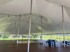 the inside of a tent with tables and chairs