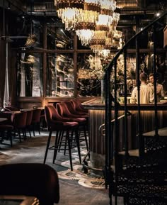 the interior of a restaurant with chandeliers hanging from the ceiling and bar stools