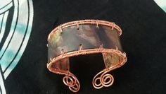 This lovely cuff bracelet has a Celtic flair. It is flexible to fit any wrist. Can be worn with swirls on top for a more elegant look or with solid side up for a more casual look. Each one is custom made so colors in main copper piece will vary slightly from photo. Elegant Copper Cuff Bracelet, Elegant Wire Wrapped Copper Cuff Bracelet, Elegant Copper Wire Wrapped Cuff Bracelet, Elegant Handmade Copper Cuff Bracelet, Artistic Copper Cuff Bracelet Bangle, Artistic Copper Cuff Bangle Bracelet, Copper Cuff Bracelet Wearable Art Gift, Unique Brown Metal Cuff Bracelet, Wearable Art Copper Bangle Bracelets