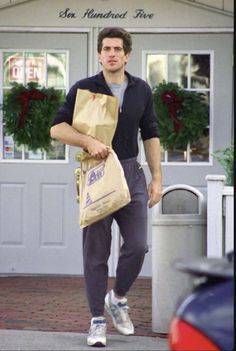 a man walking down the street carrying bags