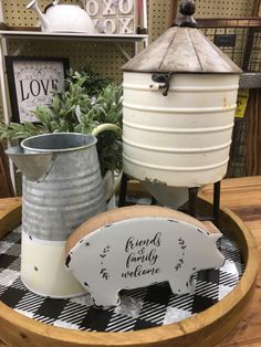 two metal buckets sitting on top of a wooden table next to a sign that says friends family welcome