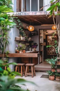 an outdoor kitchen with potted plants and wooden stools