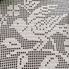 an old crocheted tablecloth with black and white designs