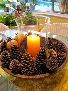 a table topped with pine cones and a candle