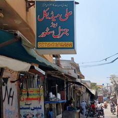 a street scene with people walking on the sidewalk and shops in arabic writing above them