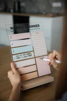 a woman is writing on a weekly planner