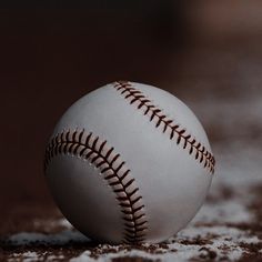 a baseball sitting on top of a field covered in snow