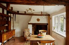 a dining room table with fruit on it in front of a fire place and window