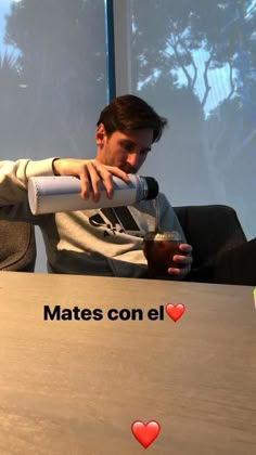 a man sitting at a table with a drink in his hand and the caption reads matees con el