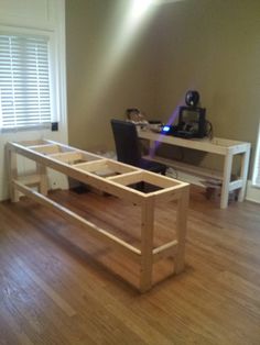 a wooden table sitting on top of a hard wood floor next to a laptop computer