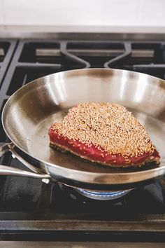 a piece of meat is cooking in a pan on the stove