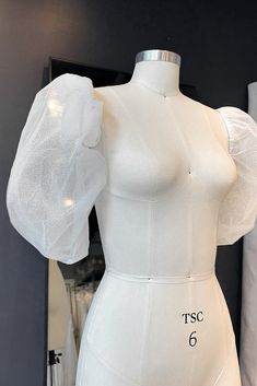 a white mannequin with sheer fabric on it